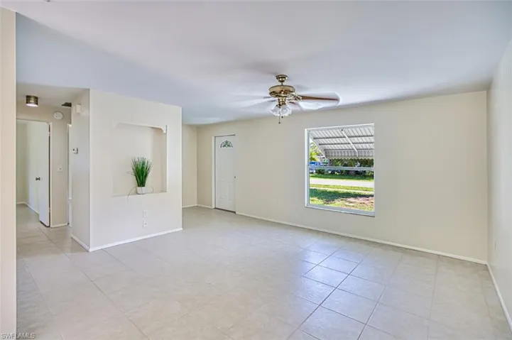 Empty room featuring ceiling fan and light tile patterned floors
