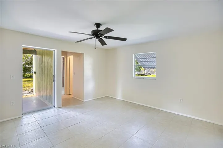 Spare room featuring healthy amount of natural light, ceiling fan, and light tile patterned floors
