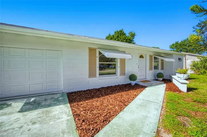 View of front facade featuring concrete block siding, a garage, and concrete driveway