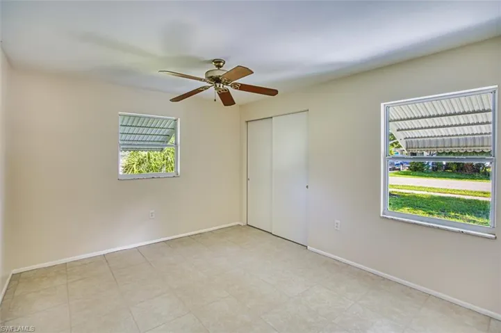 Unfurnished bedroom with ceiling fan and a closet