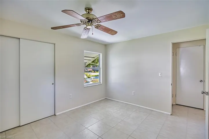 Unfurnished bedroom with a closet, a ceiling fan, and light tile patterned floors