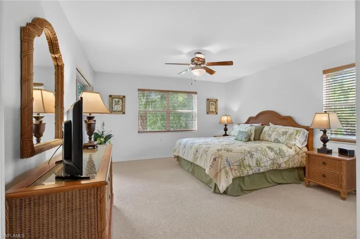 The large primary bedroom has windows on three sides, offering lovely light, while landscaping keeps the space private.