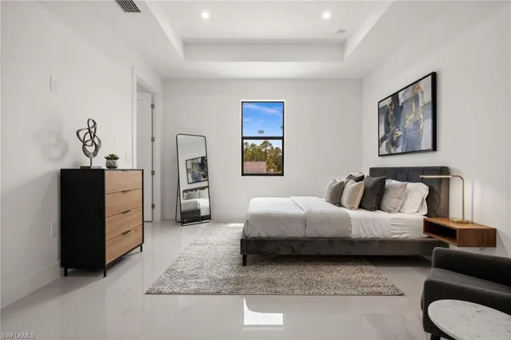 Bedroom featuring a tray ceiling and recessed lighting