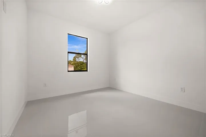 Spare room with light tile patterned flooring and lofted ceiling
