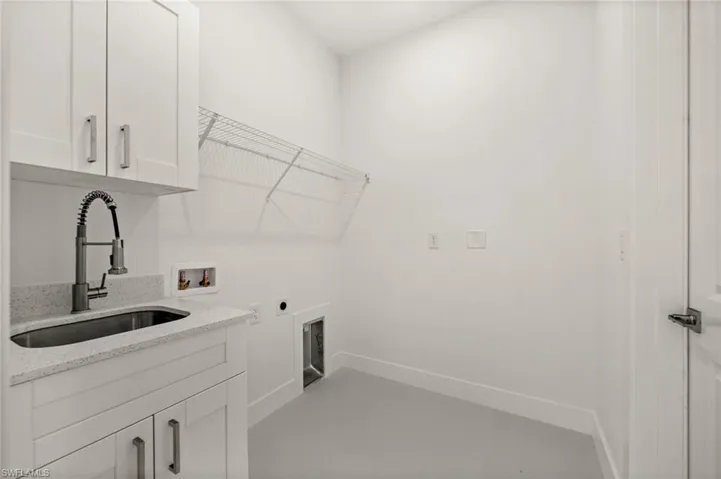Laundry room featuring electric dryer hookup, hookup for a washing machine, and cabinet space