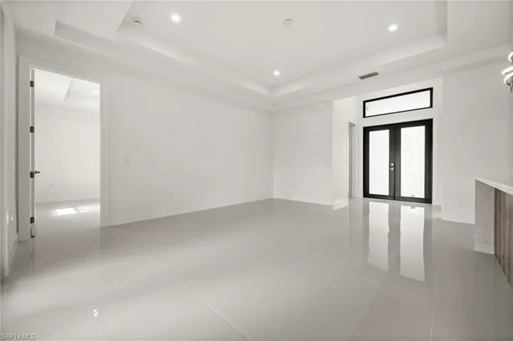 Unfurnished room featuring french doors, light tile patterned floors, recessed lighting, and a tray ceiling