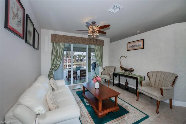Living room featuring ceiling fan and light tile patterned floors