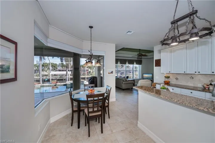 Dining area with light tile patterned floors, a chandelier, and ceiling fan