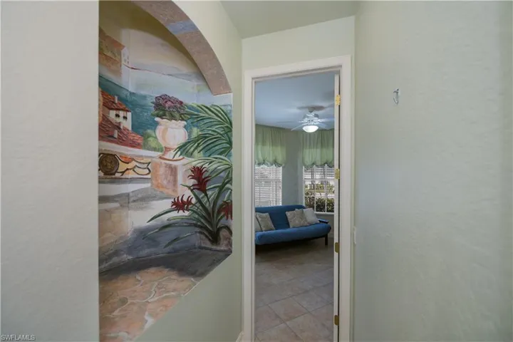 Hallway featuring a textured wall and tile patterned flooring