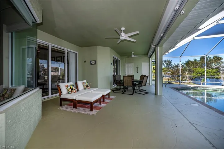 View of patio / terrace with a ceiling fan, outdoor dining area, an outdoor pool, and a lanai