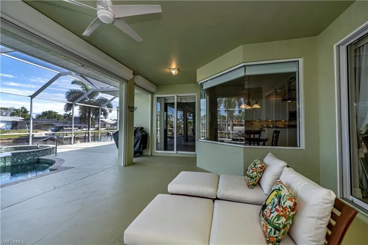 View of patio / terrace with ceiling fan, a lanai, a pool with connected hot tub, and an outdoor hangout area