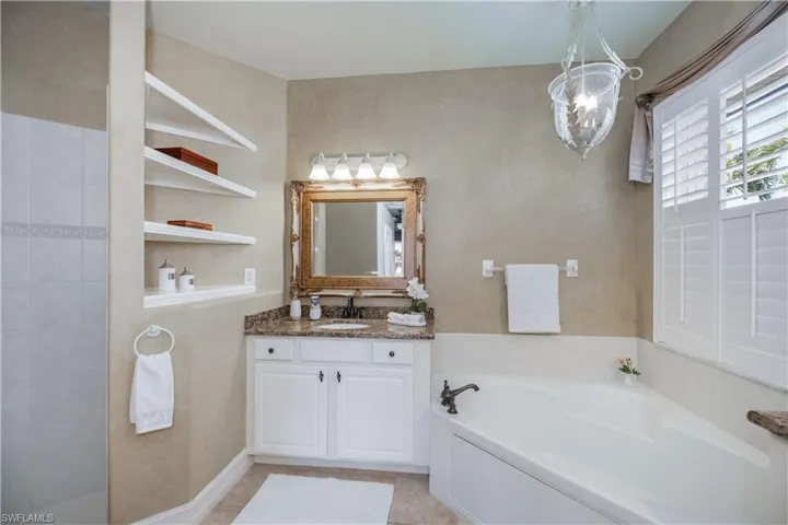Full bath featuring a garden tub, vanity, and tile patterned floors