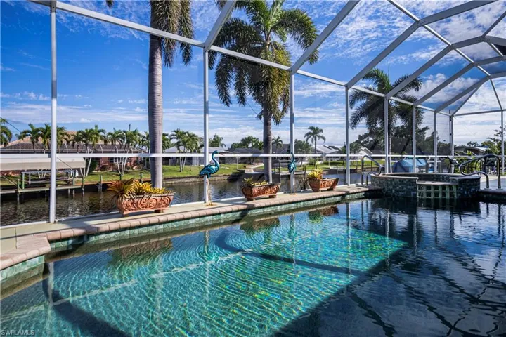 View of pool featuring a water view, a pool with connected hot tub, and a boat dock