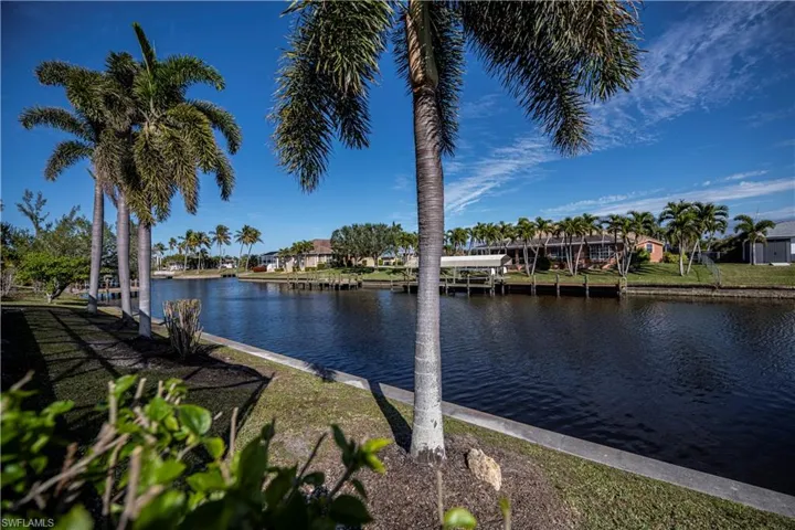 Water view with a boat dock and nearby suburban area