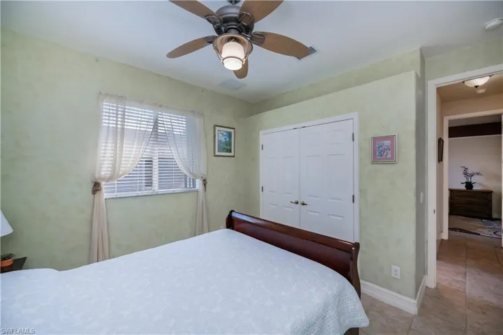 Bedroom featuring a closet, tile patterned flooring, and ceiling fan