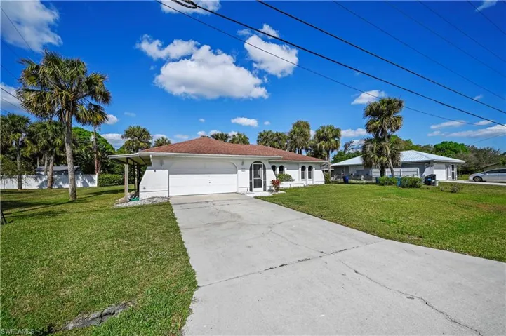 View of front facade featuring a garage and a front yard