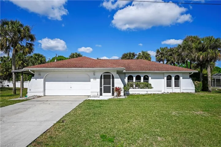 Mediterranean / spanish home featuring a garage and a front lawn