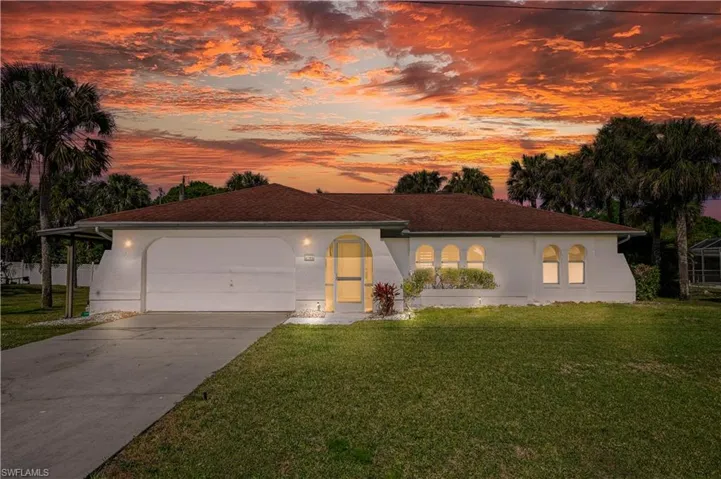 Mediterranean / spanish home with a garage and a lawn Virtual Twilight