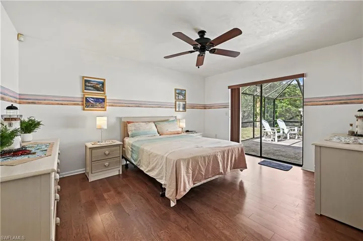 Bedroom with access to exterior, dark hardwood / wood-style floors, and ceiling fan