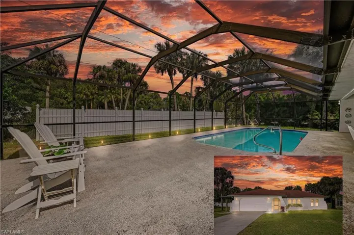 Pool with glass enclosure, a patio, and fence