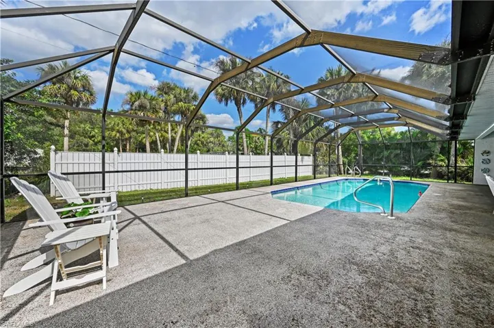 View of swimming pool featuring a lanai and a patio area