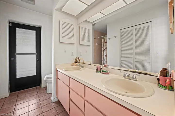 Bathroom with vanity, toilet, and tile patterned flooring