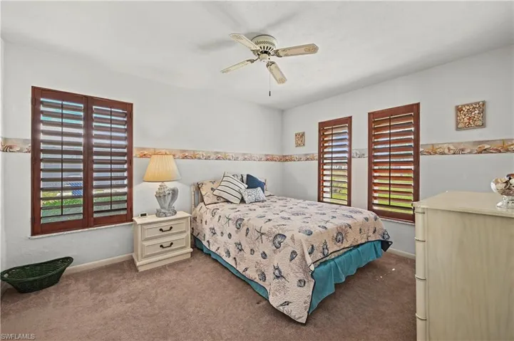 Carpeted bedroom featuring ceiling fan