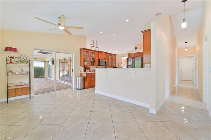 Kitchen featuring kitchen peninsula, hanging light fixtures, light tile patterned floors, sink, and stainless steel appliances