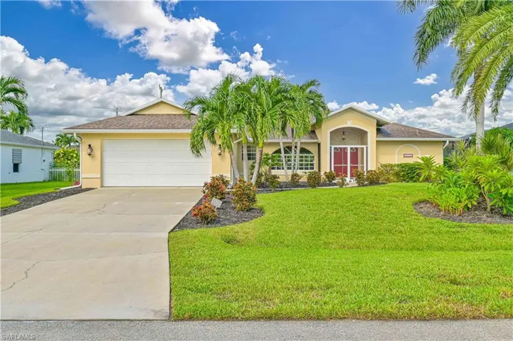 View of front of property featuring a front yard and a garage