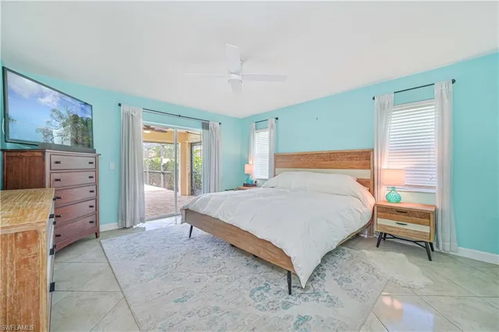 Tiled bedroom with ceiling fan and access to exterior