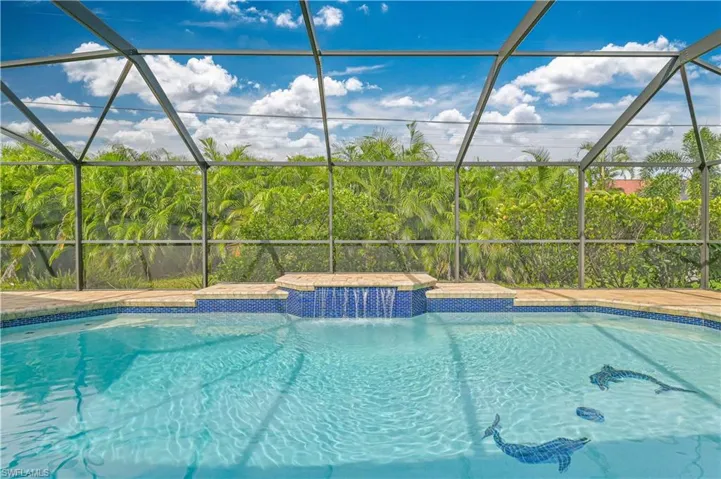 View of pool with a hot tub, a lanai, and pool water feature