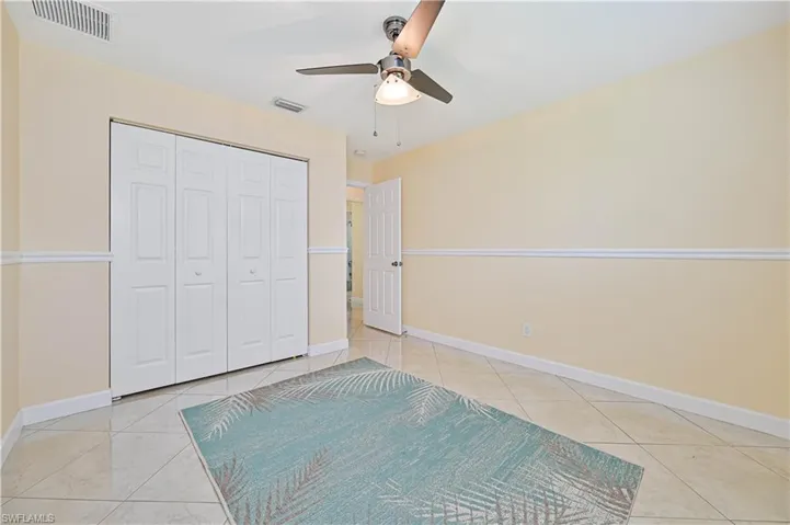 Unfurnished bedroom featuring light tile patterned floors, a closet, and ceiling fan