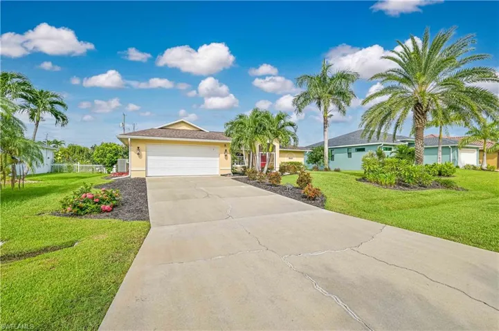 Single story home featuring a front yard and a garage