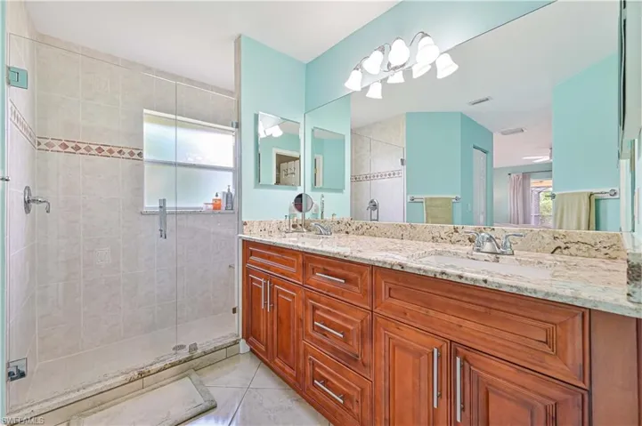 Bathroom with vanity, tile patterned floors, and walk in shower