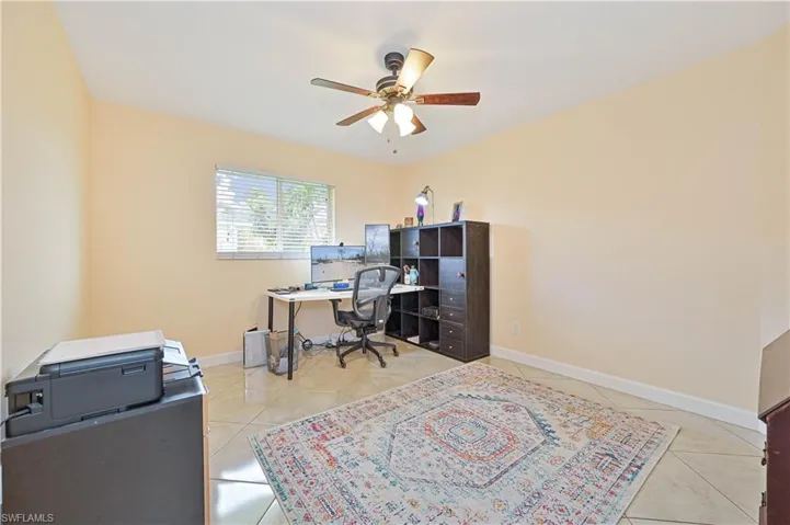 Office space featuring ceiling fan and light tile patterned floors