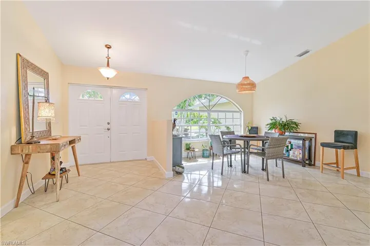 Entryway with vaulted ceiling and light tile patterned floors
