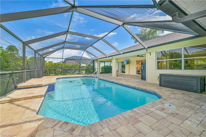 View of swimming pool featuring a patio and a lanai