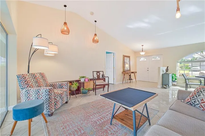 Living room featuring lofted ceiling and light tile patterned floors