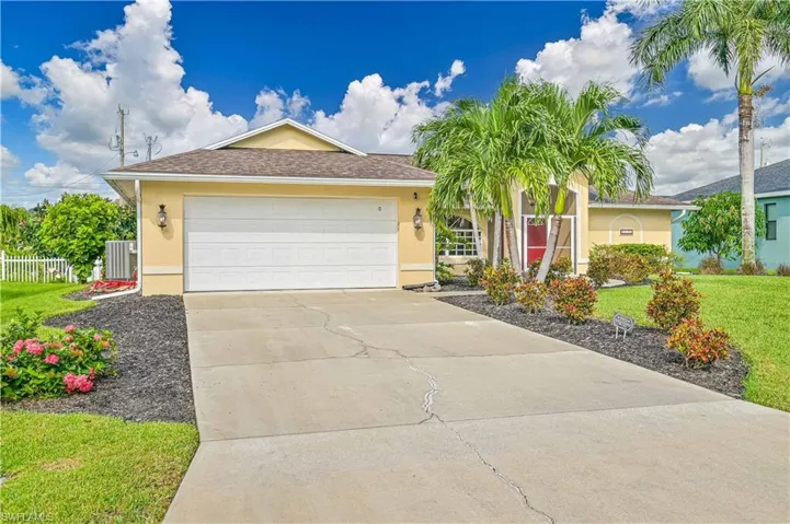 Ranch-style home with central air condition unit, a front lawn, and a garage