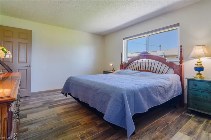 Bedroom featuring a textured ceiling and dark hardwood / wood-style floors