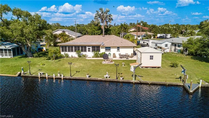Back of house featuring a water view, a yard, and an outdoor structure