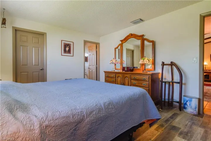 Bedroom with a textured ceiling and dark hardwood / wood-style floors