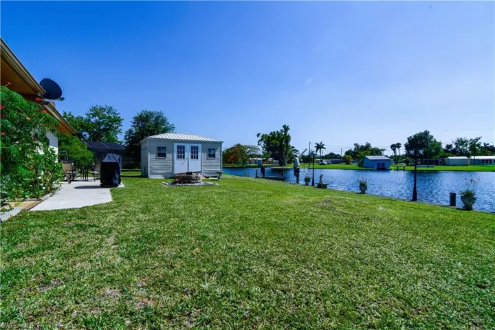 View of yard featuring a storage shed and a water view