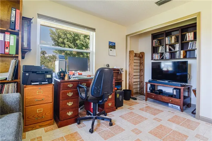 Tiled home office featuring a textured ceiling