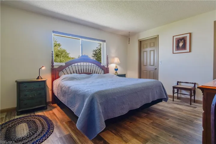 Bedroom featuring dark wood-type flooring and a textured ceiling