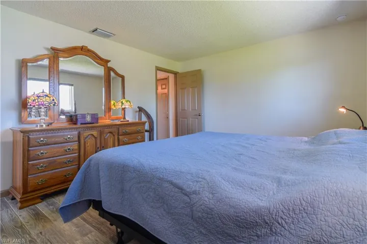 Bedroom featuring a textured ceiling and dark wood-type flooring