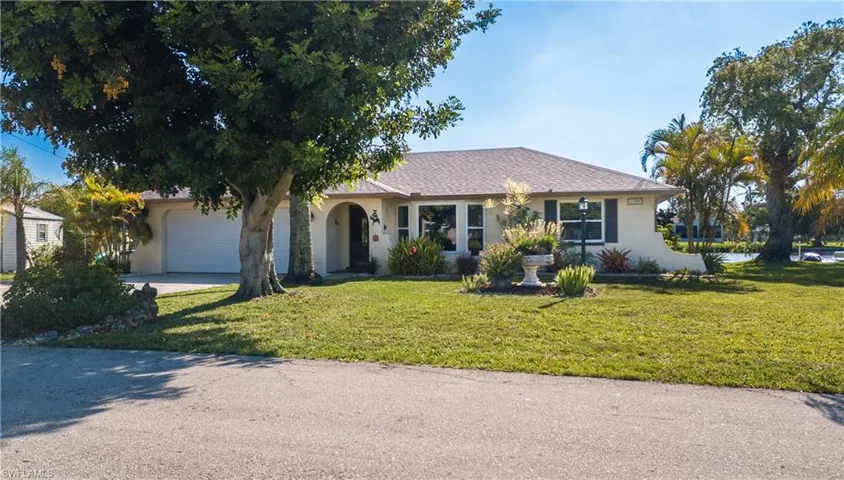 Ranch-style house featuring a garage and a front yard