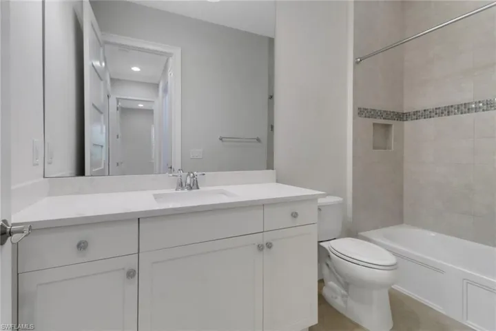 Full bath with vanity, toilet,  shower combination, and recessed lighting