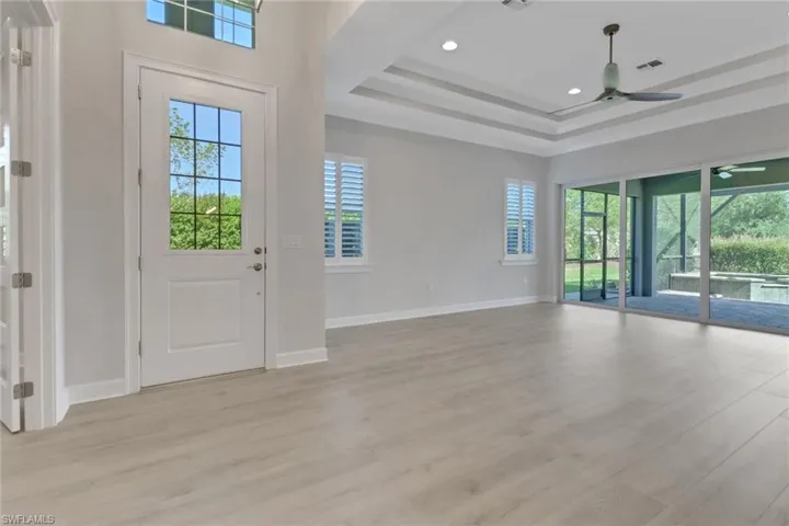 Entrance foyer with light wood-type flooring, a ceiling fan, plenty of natural light, and visible vents