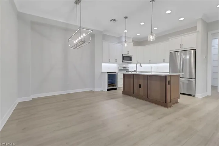 Kitchen featuring wine cooler, baseboards, visible vents, a sink, and appliances with stainless steel finishes